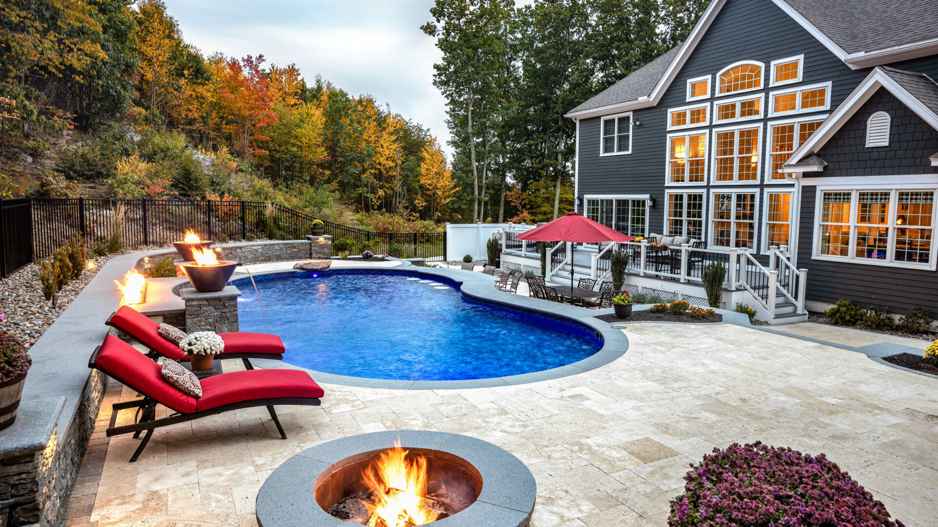 Chairs and fire pits surrounding a pool.