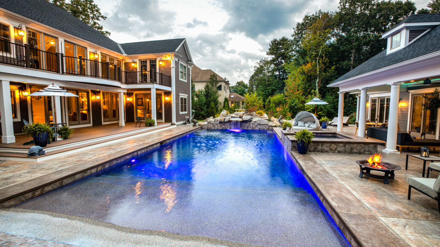 Stamped concrete pool deck, spa, and water fall at a Residential Landscape Design & Build Project in Massachusetts.
