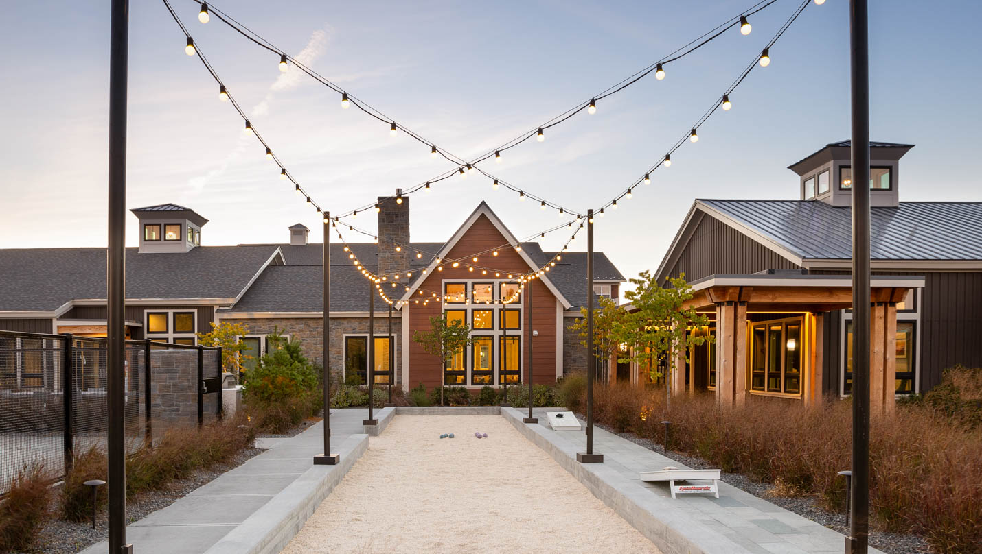 Outside community space. Bocci court with string lights. Dex by Terra landscape design-build project.