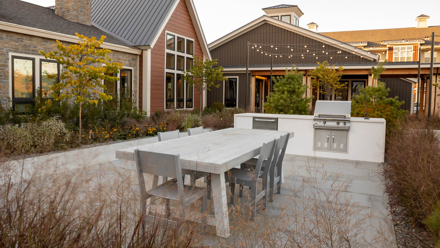 Outdoor dining area patio and outdoor kitchen at a Dex by Terra commercial landscape design-build project.