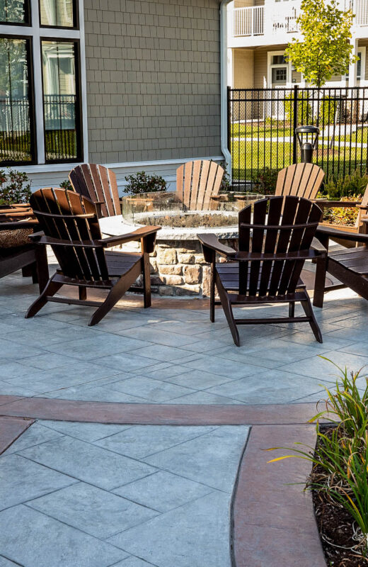 Chairs around a fire pit in a housing community.