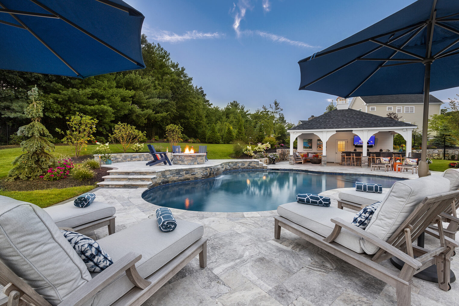 Landscape & Hardscape Design with pool deck, patio, and fire pit, built by Dex by Terra, at a home in Norfolk, MA.