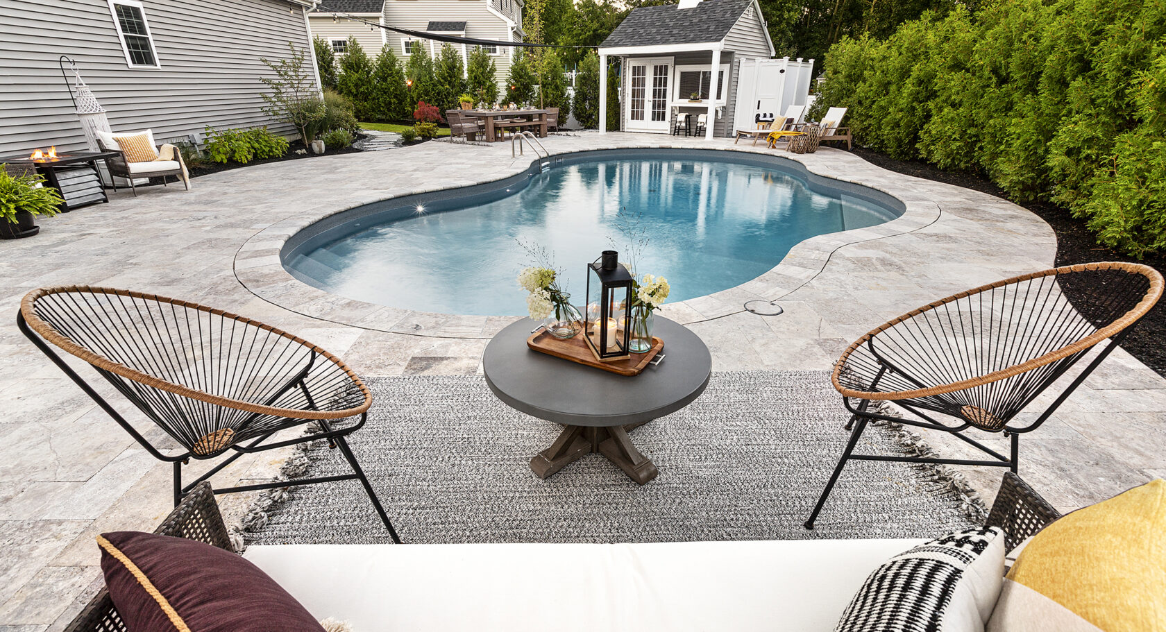 Pool deck lounge area at Dex by Terra's residential hardscape design-build project in Shrewsbury, MA.