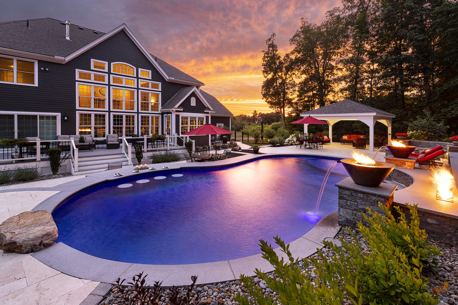 Dex by Terra Pool deck, water/fire features, and jump rock, looking toward the back of the home in Sterling, Massachusetts