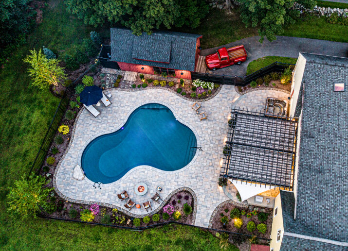 Drone view of paver pool deck. Dex by Terra Residential Landscape Design-Build in Stow, MA.