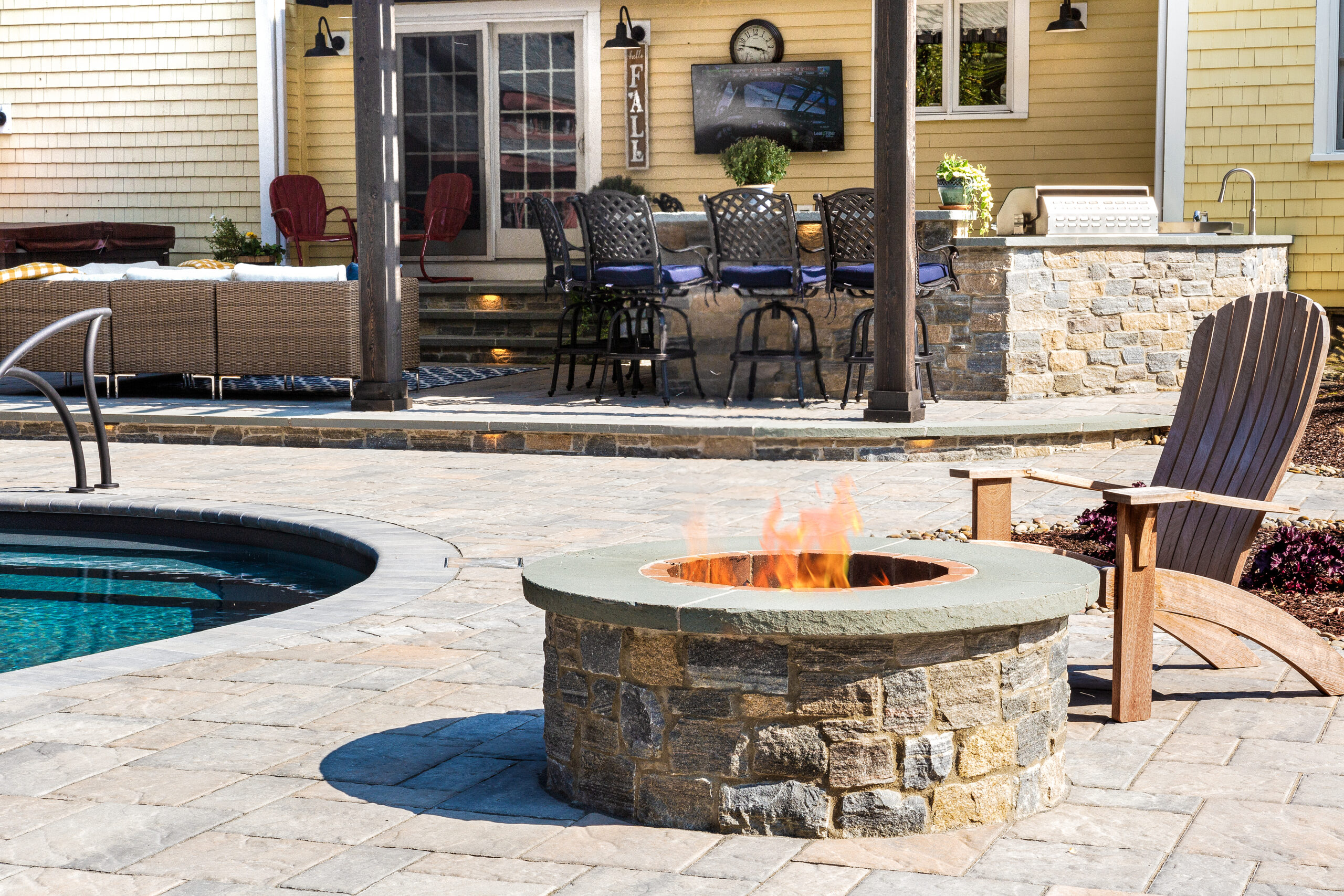 Chair by outdoor fire pit next to pool.