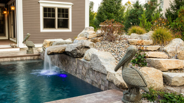 Pool fountain with pelican statues and natural stone steps.