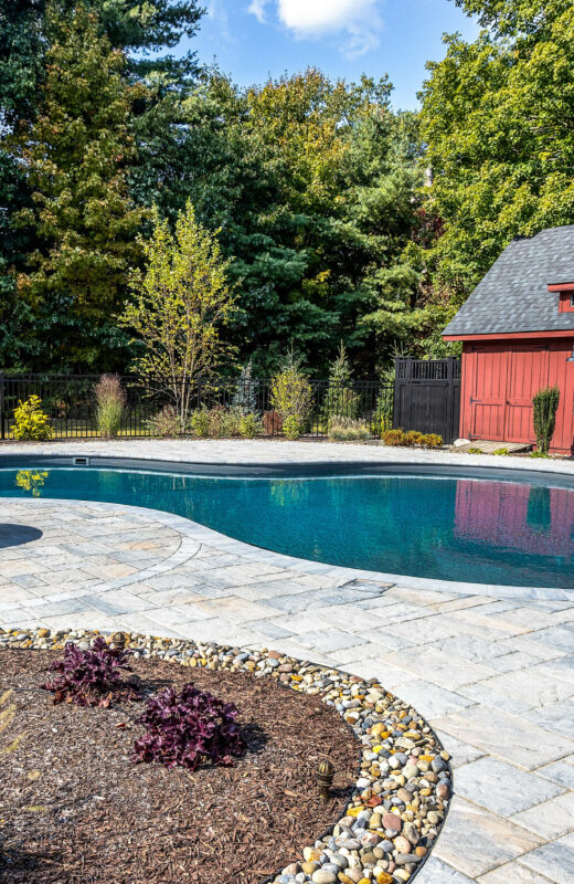 Pool with lounge chairs and a fire pit.