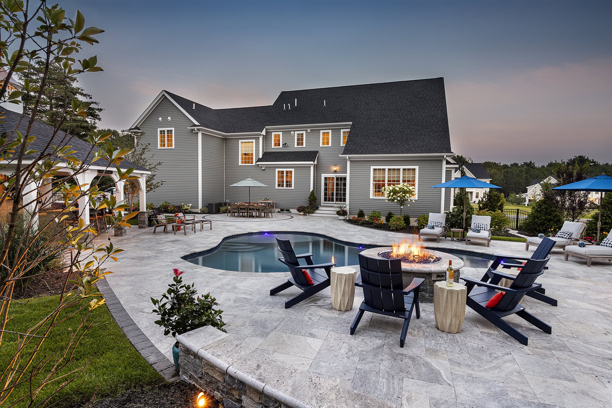 Elevated gas fire pit overlooking gunite inground pool and back of home. Dex by Terra landscape design-build in Norfolk, MA.