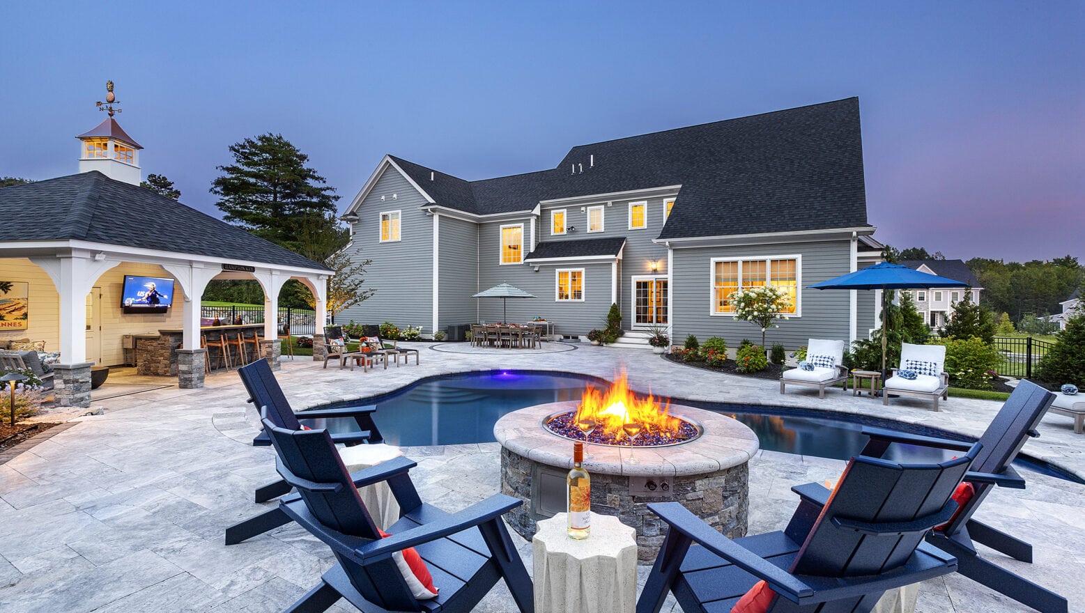 Poolside fire pit overlooking backyard hardscaping. Dex by Terra Residential Landscape Design & Build Project in Norfolk, MA