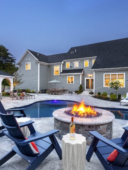 Poolside fire pit overlooking backyard hardscaping. Dex by Terra Residential Landscape Design & Build Project in Norfolk, MA