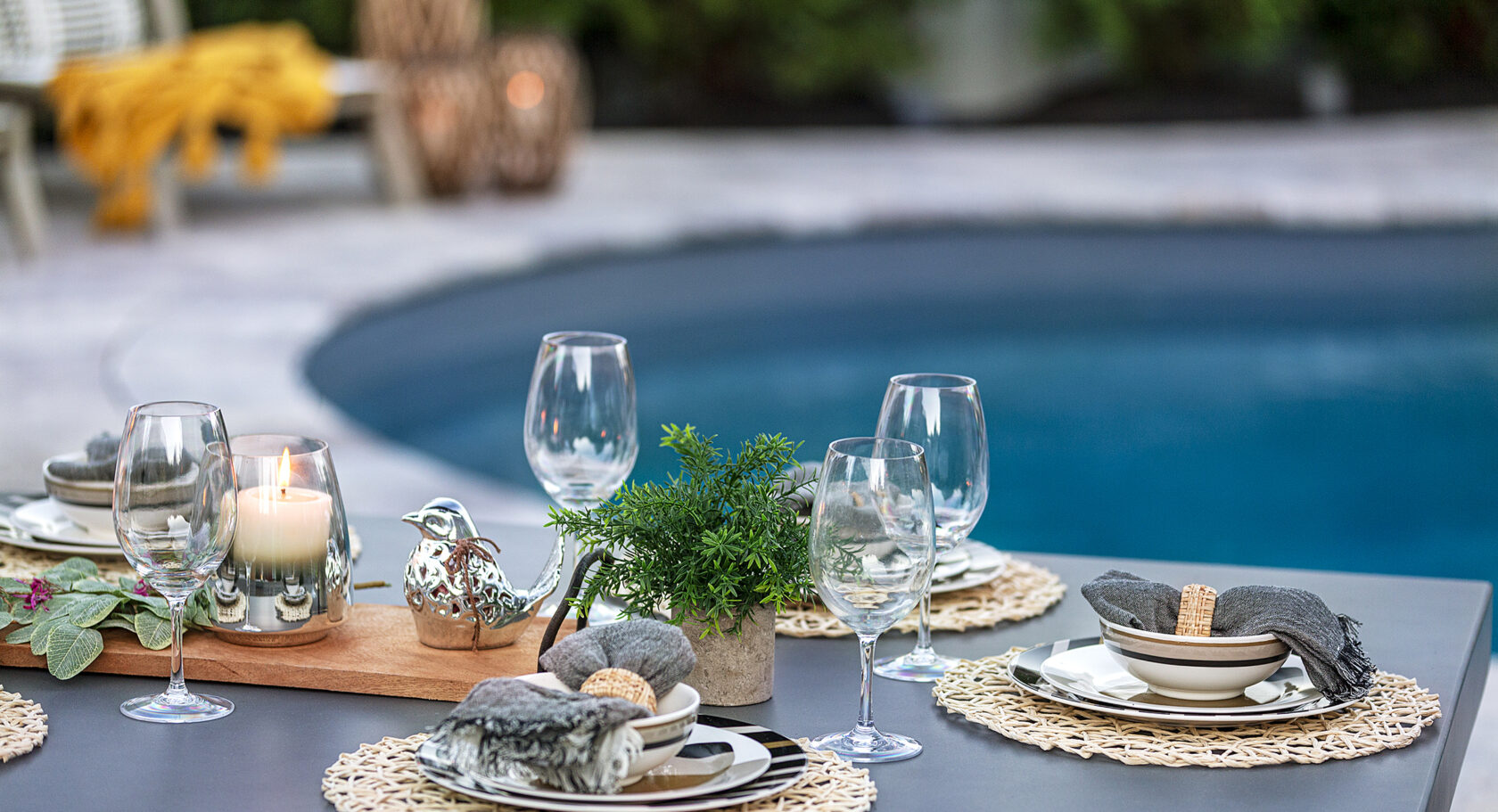 Place settings on a poolside dining table. Dex by Terra landscape design and build project in Shrewsbury MA.