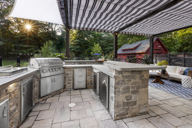 Outdoor Kitchen with grill, and stainless steel appliances under pergola. Dex by Terra residential hardscape in Stow, MA.