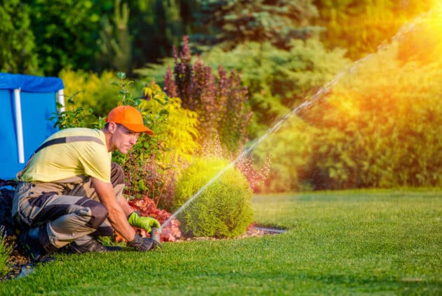 Irrigation worker servicing sprinkler system in the summer.