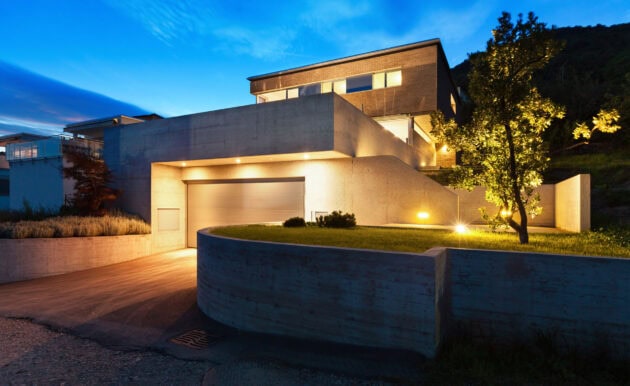 Modern home with landscape lighting at dusk.