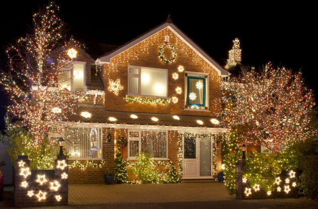 A large display of Christmas Lights outside on a house and in the garden