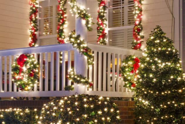 Close up detail of a home that is beautifully decorated for the Holiday Season with lights, ornaments, wreaths and garlands.