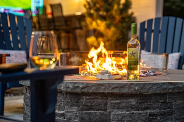 Wine and s'mores by a gas fire pit. Dex by Terra Hardscaping & Landscaping project in Whitinsville, MA.