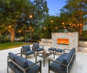 Patio furniture, with wine and cheese by a gas outdoor fireplace. Dex by Terra Hardscaping & Landscaping in Needham, MA.