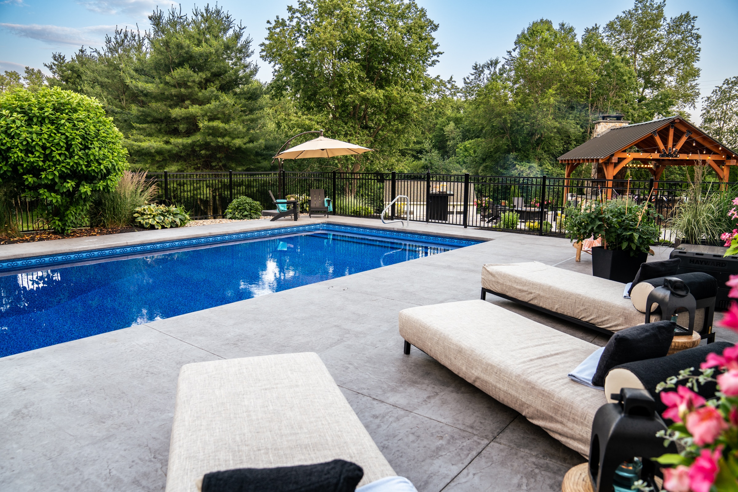 Poolside lounge chairs adorn the large seamless stamped concrete pool deck and are the perfect place to relax.