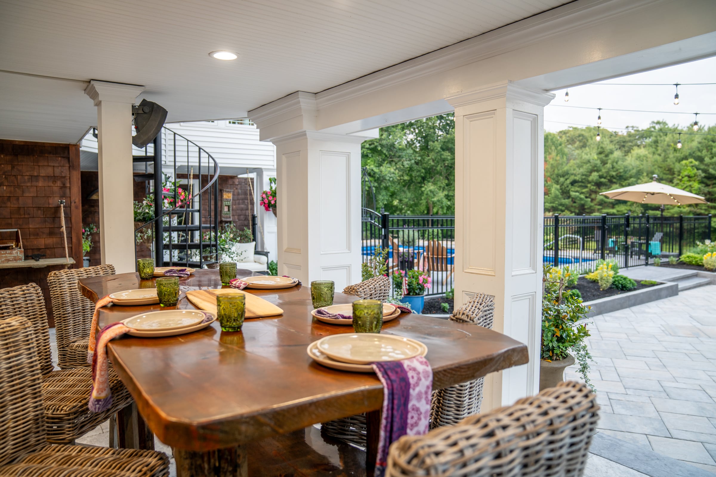 The covered outdoor dining patio was built using natural travertine stone pavers, and is an elegant place to host a dinner party throughout the warm New England months.