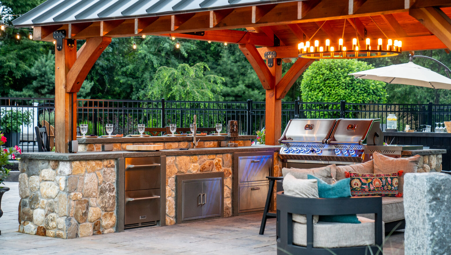 The outdoor kitchen under the client built pergola was furnished with professional grade appliances. New England Rounds stone veneer was used to build the kitchen.