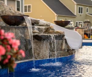 Water and fire features flank the custom waterslide built by Dex by Terra in Grafton, Massachusetts.
