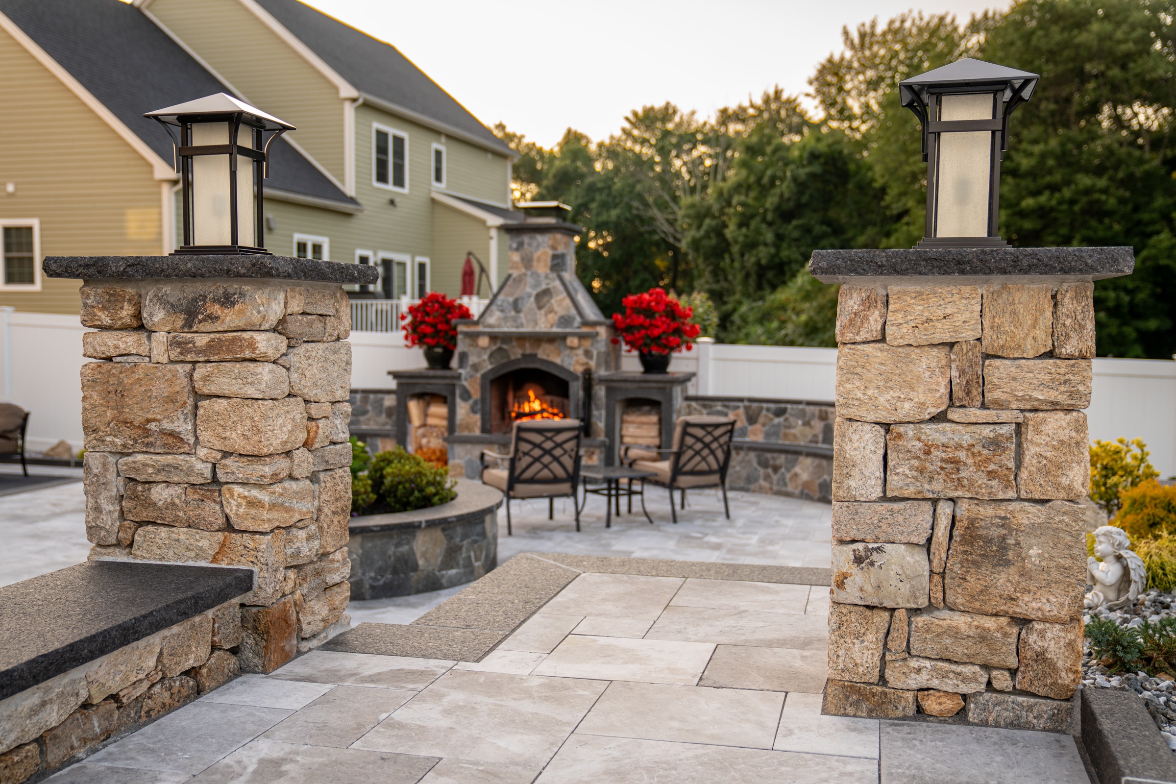 Natural stone columns flank the walkway that leads to the fireplace patio. Dex by Terra Hardscape project in Grafton, MA.