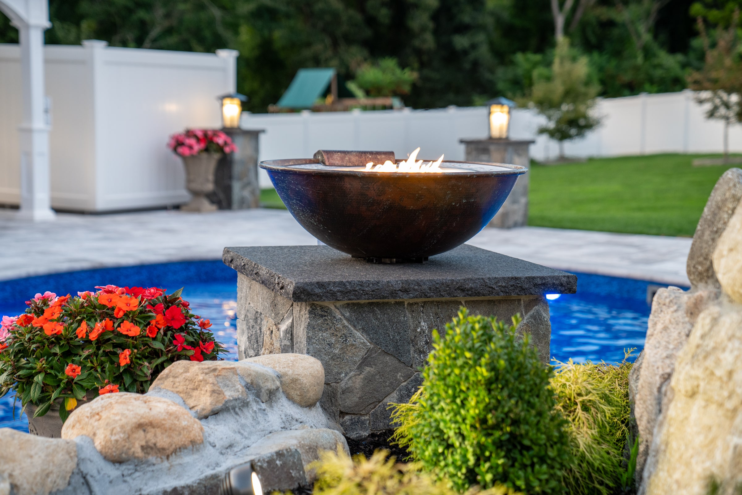Dex by Terra installed this water and fire feature has been installed next to the pool, enhancing this backyard in Grafton, Massachusetts.