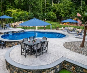 Northbridge, MA hardscape with stamped concrete walkways, pool deck, poolside bar, and sundeck, all built by Dex by Terra.