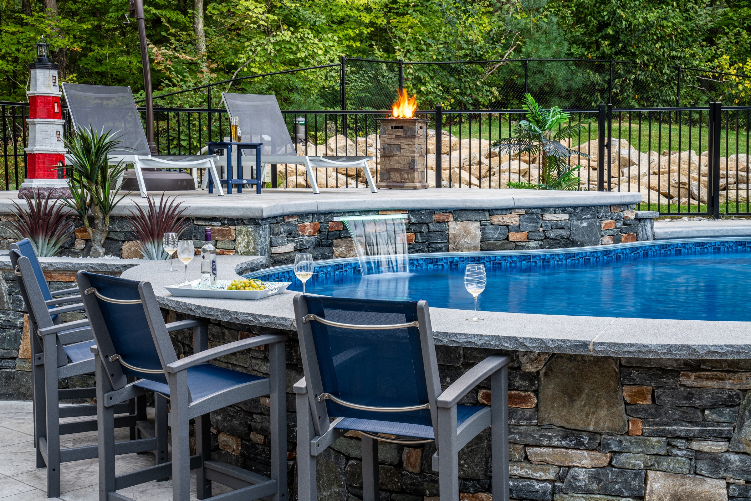 This poolside bar is built with a granite bar top and stone veneer. Dex by Terra Hardscape project in Northbridge, Massachusetts.