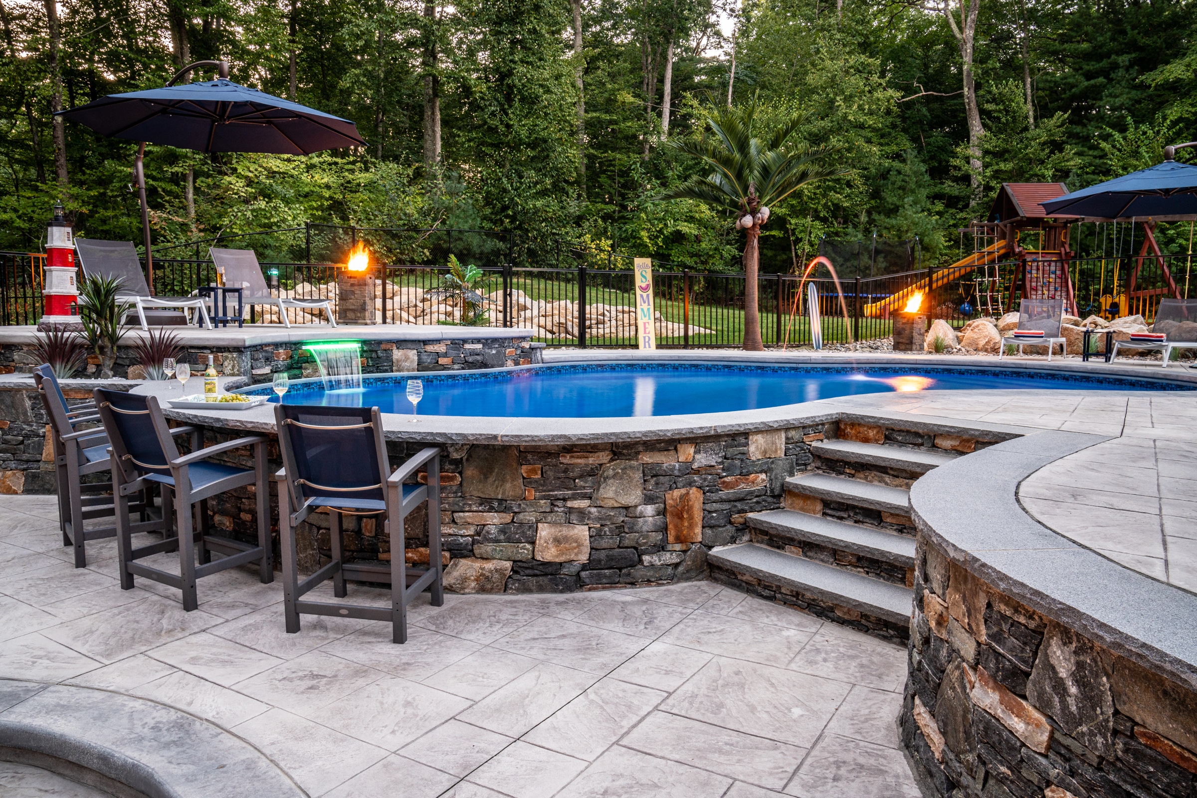 Dex by Terra created an elevated pool deck with a sunken fire pit lounge to accommodate a significant slope in the client's yard.