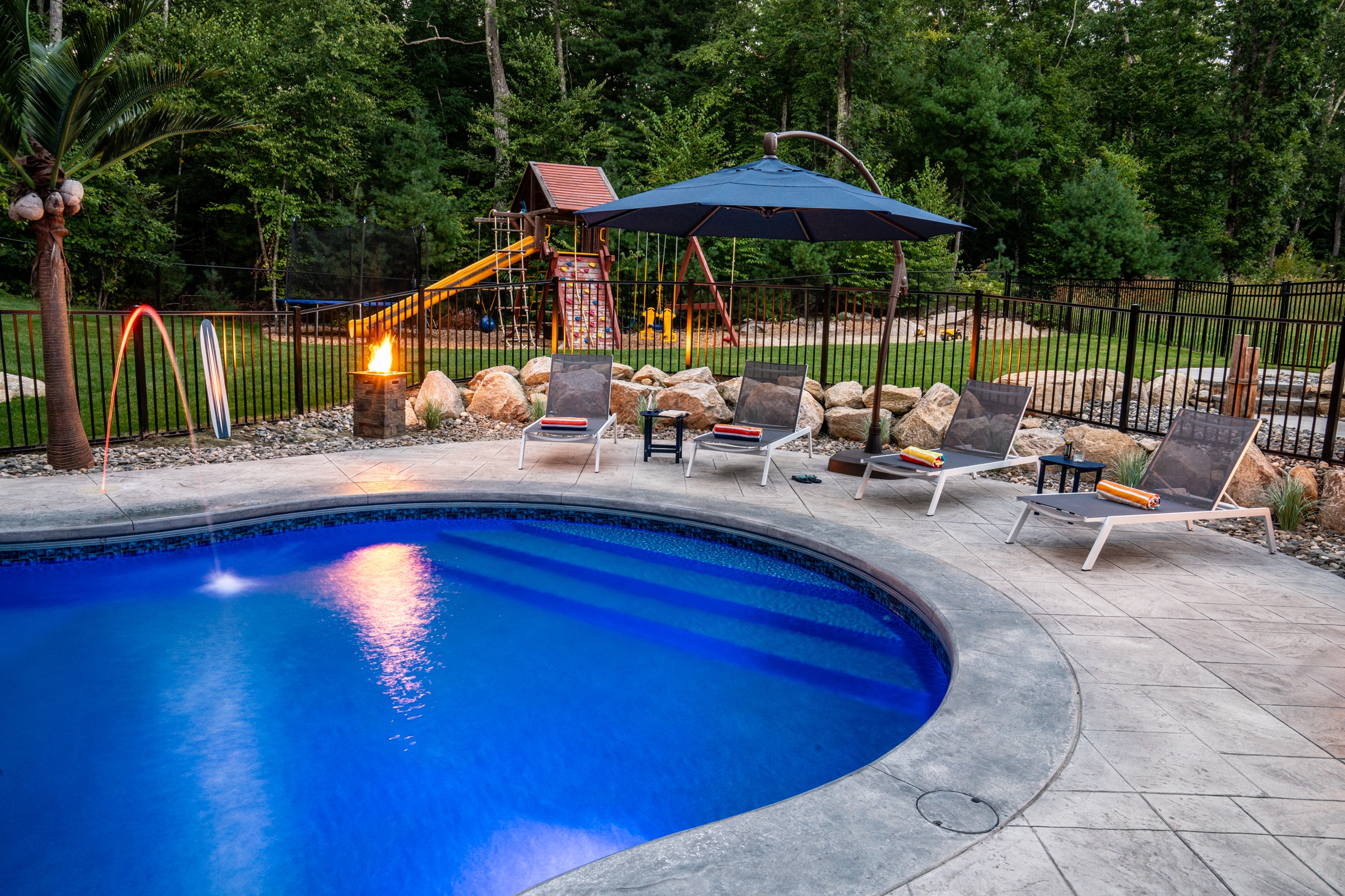 Step into the water from this beautiful stamped concrete pool deck featuring an integrated water jet, built by Dex by Terra.