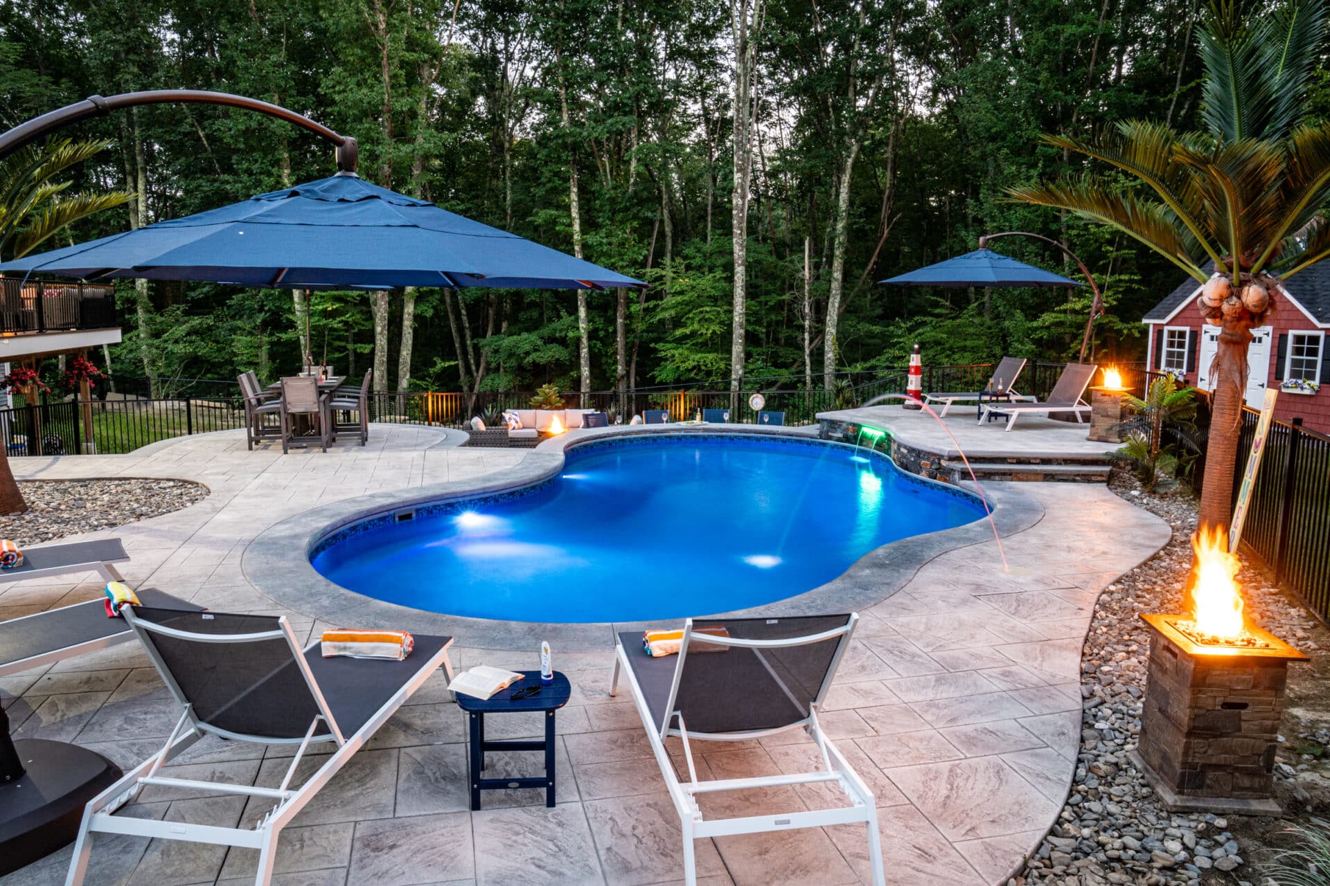 Northbridge, MA hardscape with a stamped concrete pool deck, poolside bar, sundeck, and water feature built by Dex by Terra.