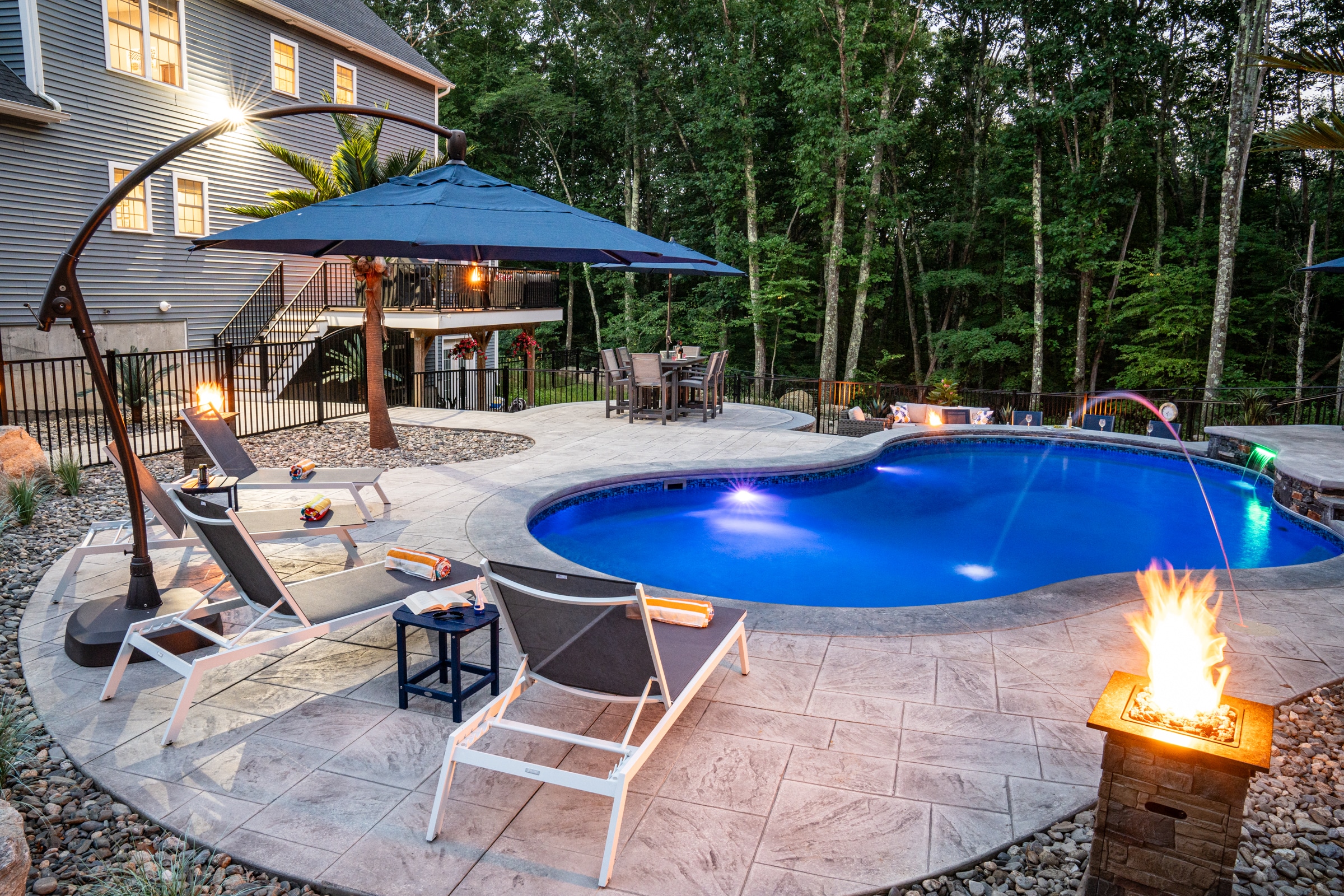 By the glow of fire pits and pool lights, parties can extend well into the evening at this Dex by Terra hardscape project.