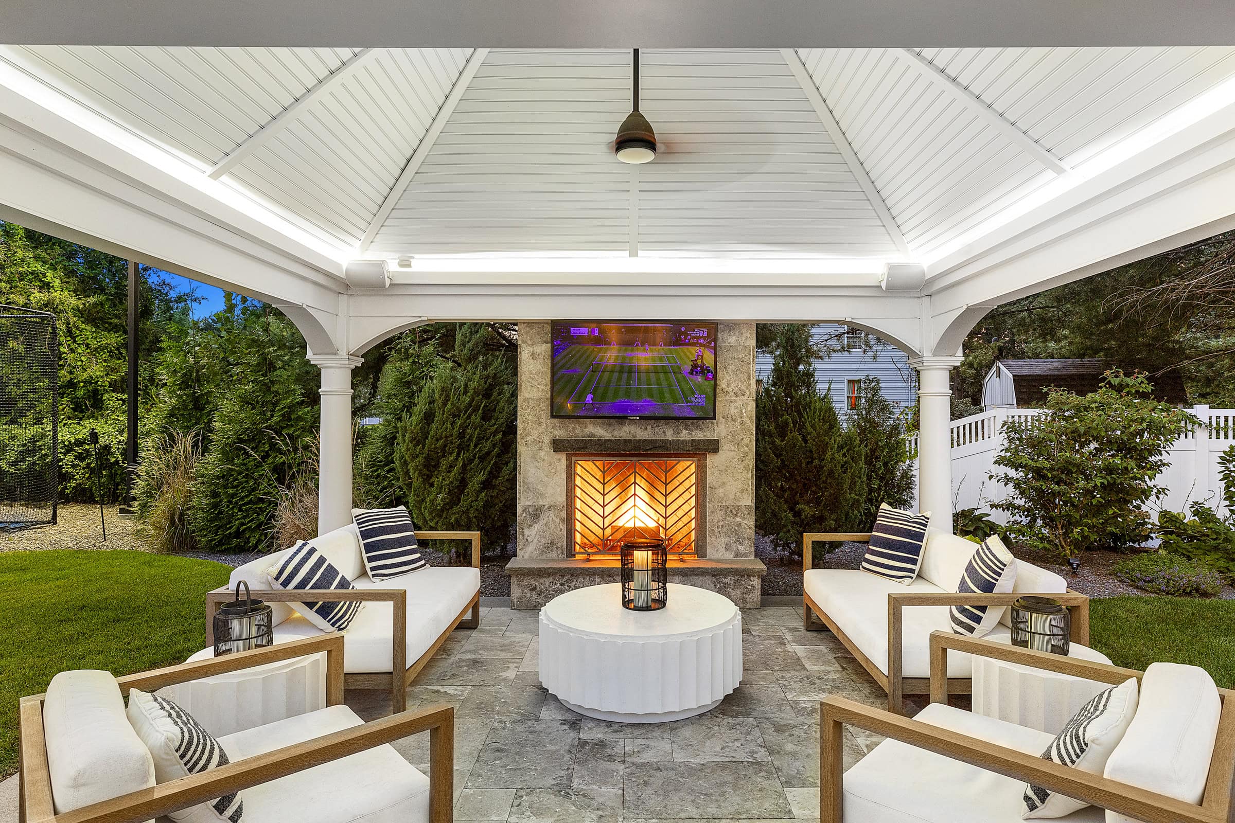 Gazebo patio with stone fireplace and TV. Dex by Terra Landscape design / build project in Andover, Massachusetts.