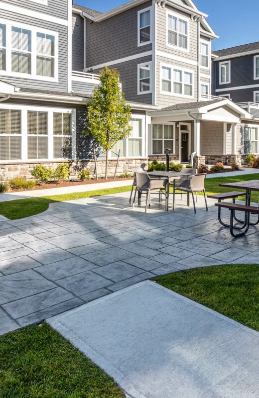 Stamped concrete patio with outdoor kitchens in a luxury apartment amenity area in MA. Commercial hardscape by Dex by Terra.