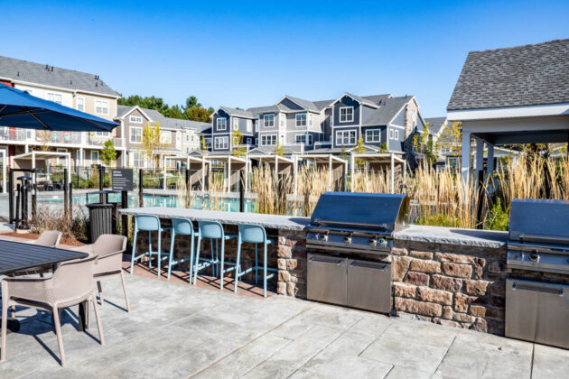 Resident amenity area with outdoor kitchens and stamped concrete patio. Commercial hardscape project by Dex by Terra.
