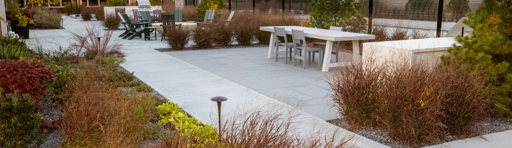 Amenity area with table, chairs, & outdoor kitchens. Luxury apartments in Marlboro, MA. Dex by Terra Hardscape & Landscape.