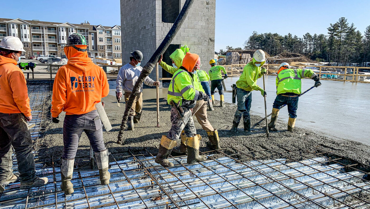 Commercial Site & Construction Services - Dex by Terra workers pouring concrete slab with rebar.