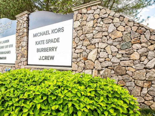 Wrentham shopping center signage with plants.