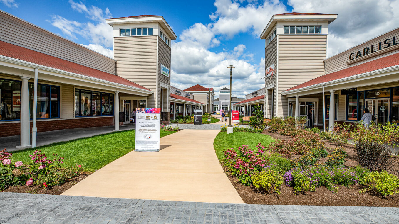 Wrentham Outlets shopping center with concrete & paver walkways. Commercial hardscape & landscape project by Dex by Terra.