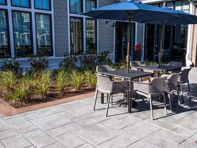Stamped concrete patio with table and chairs. Amenity area at Avalon Luxury Apartments in Sudbury, MA. work by Dex by Terra.