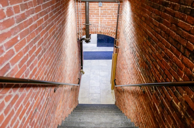 Indoor, brick-lined, stone stairway after restoration & repointing. Dex by Terra Commercial Masonry project in MA.