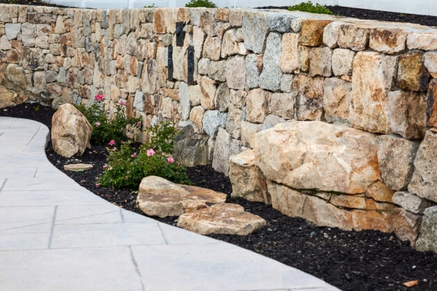 Natural Stone Retaining Wall with mulched flowerbed. Dex by Terra masonry service in MA & NH.