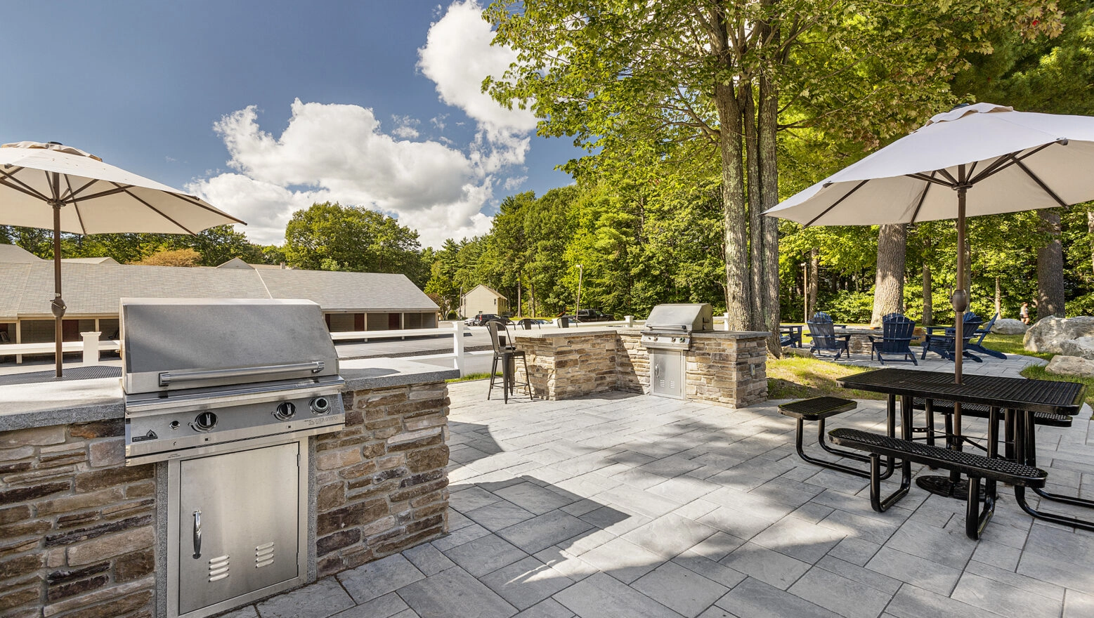 Grill stations and seating in the resident amenity area at Cranmore Ridge Apartments in Concord, NH. Dex by Terra Hardscape.