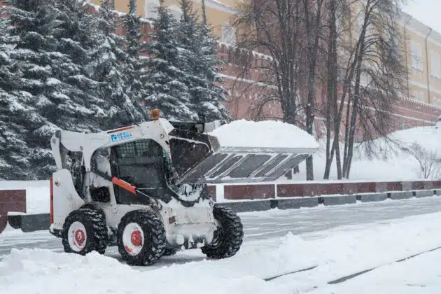 Dex by Terra bobcat hauling snow away at a commercial snow removal job site.